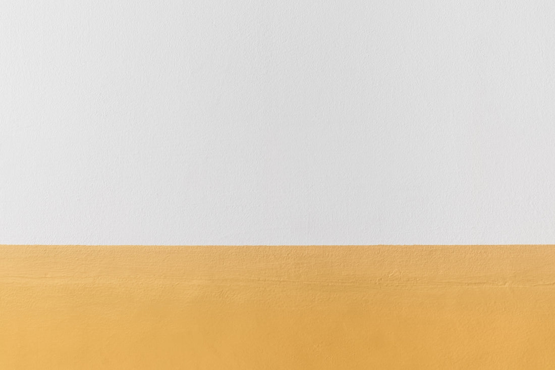 a white and yellow wall with a black and white clock