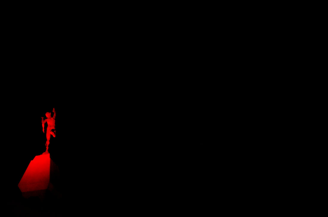 a person standing on top of a red object in the dark