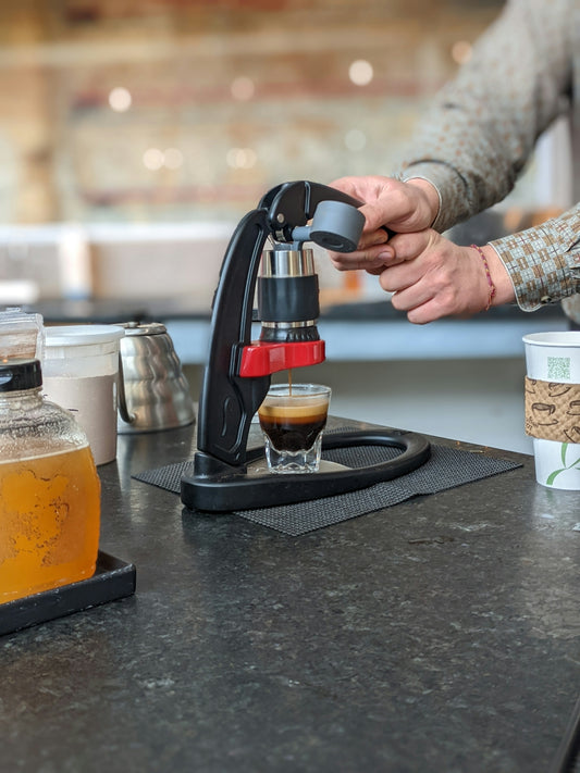 a person is filling a cup of coffee from a coffee maker
