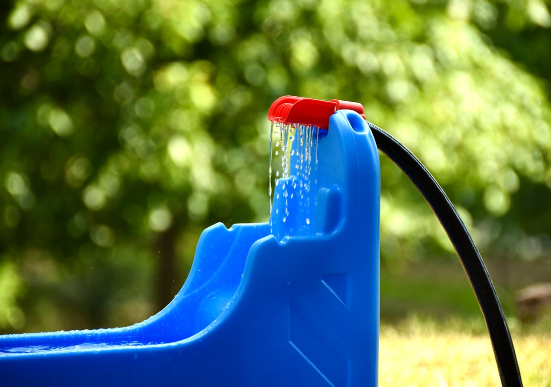 a blue water fountain with a red spout
