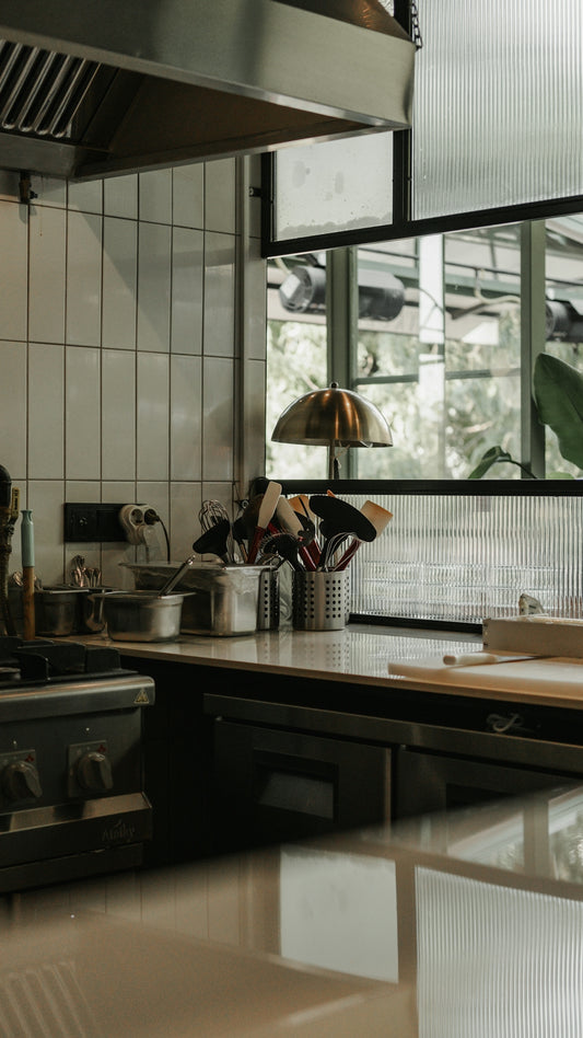 A kitchen with a stove top oven sitting next to a window