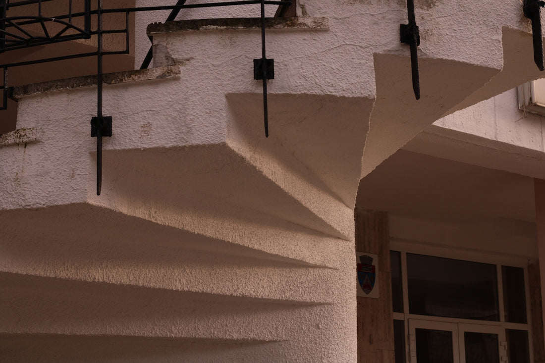 Curved exterior stairs with decorative black railings.