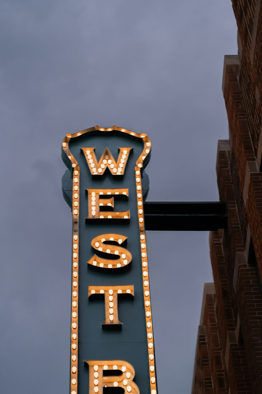 A lit-up sign reads west in an outdoor shot.
