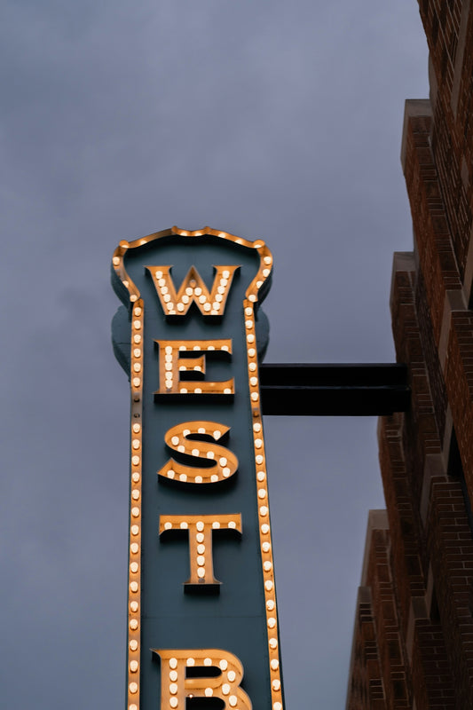 A lit-up sign reads west in an outdoor shot.