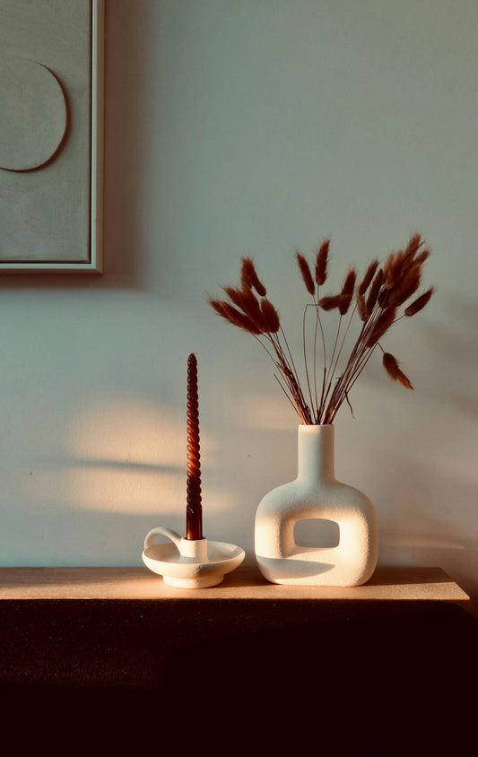 Candle and dried flowers in a modern vase.