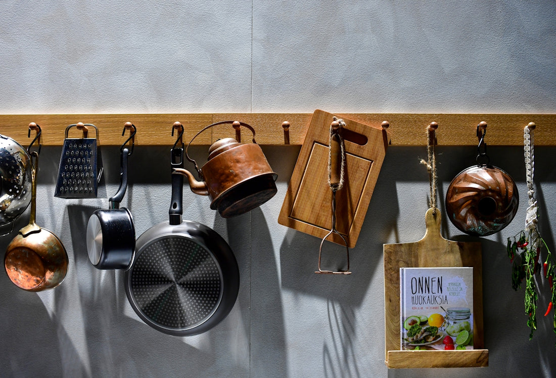 Kitchenware hanging on a wooden rack against wall