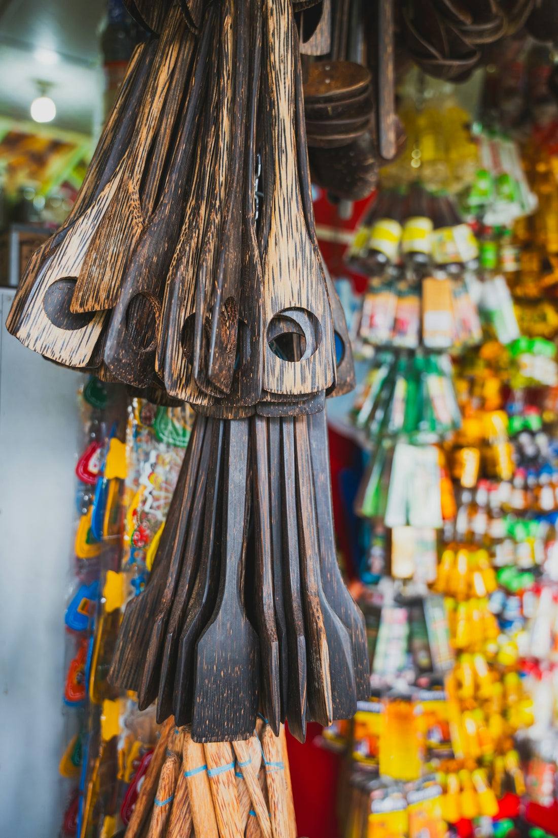 Dark wooden kitchen tools hanging in a vibrant market
