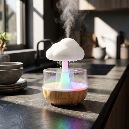 Small Rain Cloud Humidifier with vibrant LED lighting on a dark stone countertop in a contemporary kitchen setting.