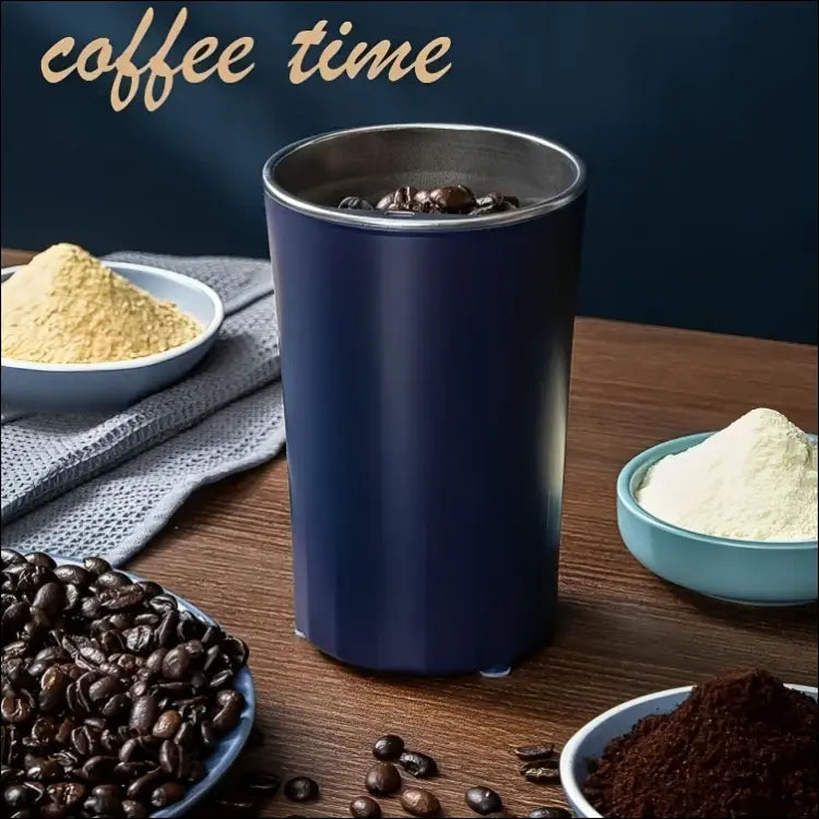 Dark blue GrindMaster Go coffee grinder with whole coffee beans inside.