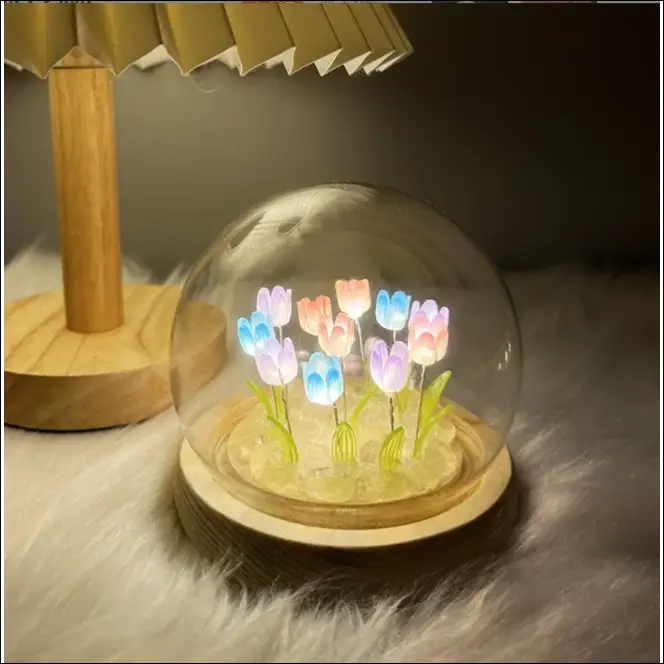 Illuminated tulips inside glass dome, decorative flowers on wooden base.