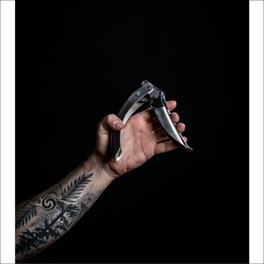 Hand holding ProPress garlic crusher with ergonomic design.